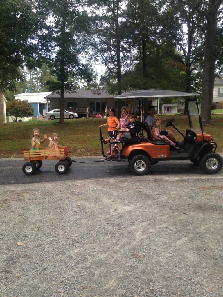A slew of grandkids on a golf cart